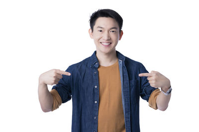 Portrait of young man standing against white background