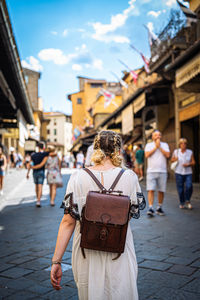 Rear view of women walking on street in city