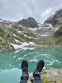 Low section of person on rock by lake