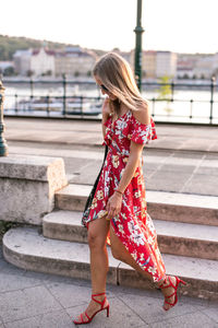 Full length of young woman standing on steps