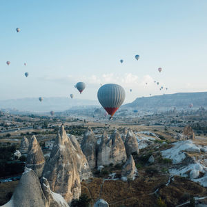 Hot air balloons flying over landscape against sky