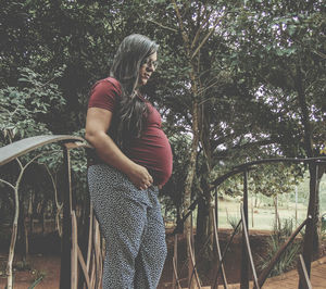 Young woman standing by tree