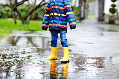 Low section of child standing on puddle