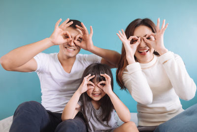 Portrait of happy family making hand masks while sitting on bed at home