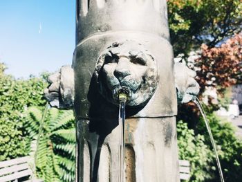 Close-up of statue by plants against sky
