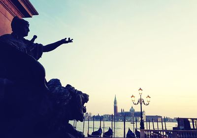 Low angle view of silhouette statue against sky at sunset