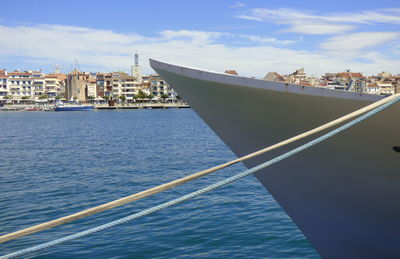 Boat sailing on sea against sky in city