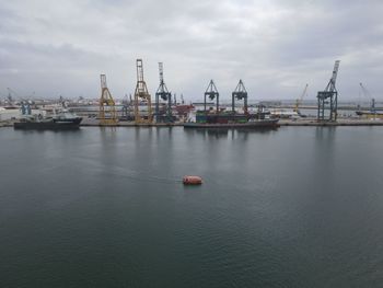 Commercial dock by sea against sky