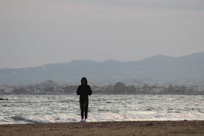 Rear view of man standing on beach