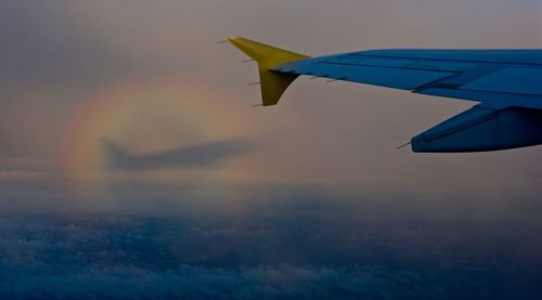 Cropped image of airplane flying over cloudy sky