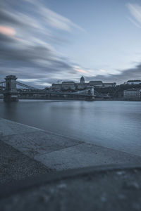 View of bridge over river against cloudy sky