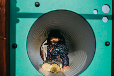 Portrait of cute girl sitting in playing tunnel