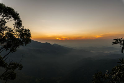 Scenic view of silhouette mountains against sky at sunset