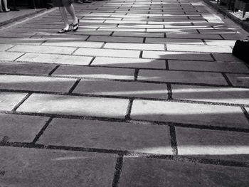 Low section of people standing on tiled floor