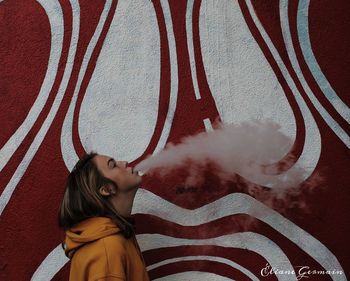 Portrait of smiling woman against wall