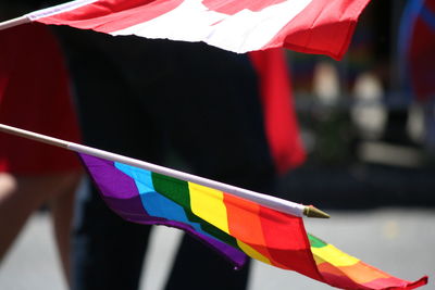 Close-up of hand holding multi colored flags