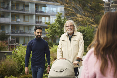 Men with baby stroller walking in residential area