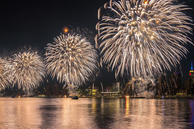 Firework display over river at night