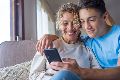 Happy friends using mobile phone