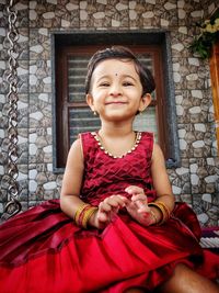 Portrait of smiling girl sitting outdoors