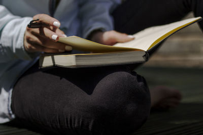 Midsection of man reading book