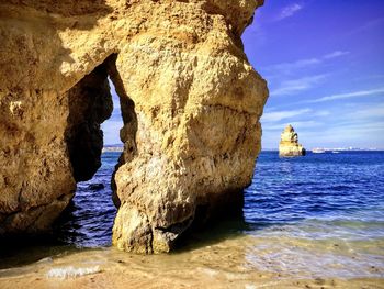 Rock formation in sea against sky