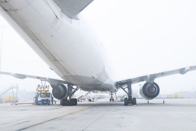 Low angle view of airplane on airport runway against sky