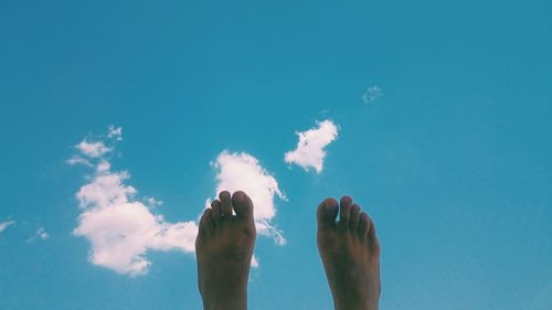 Low section of man against blue sky