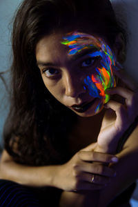 Portrait of beautiful young woman with multi colored face