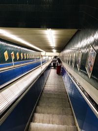 People on illuminated escalator