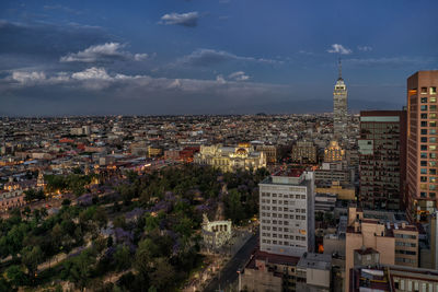 Aerial view of city against cloudy sky