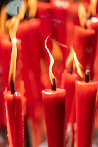 Close-up of lit candles on glass