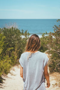 Rear view of man looking at sea against sky