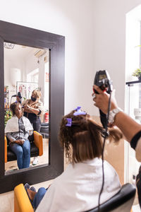 Side view of young woman photographing while sitting at home