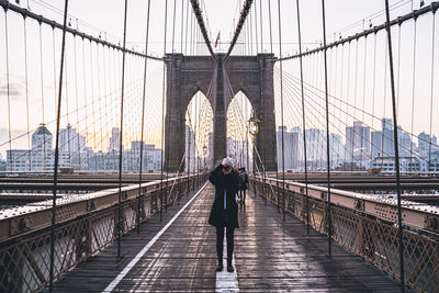 Rear view of man walking on footbridge