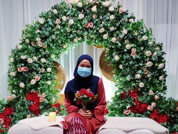 Midsection of woman sitting on flower bouquet