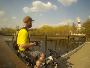 Man riding bicycle on railing in city