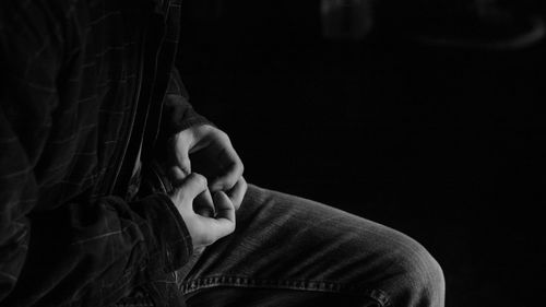 Midsection of man over black background