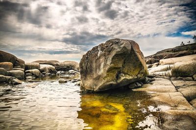 Rocks by sea against sky