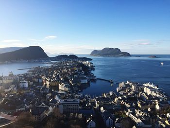 High angle view of city by sea against sky