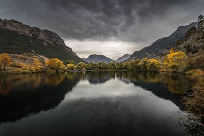 Scenic view of lake by mountains against sky