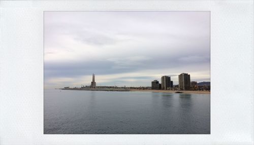 View of cityscape against cloudy sky