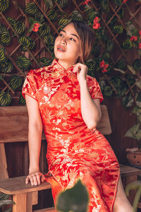 Full length of a smiling young woman sitting on seat