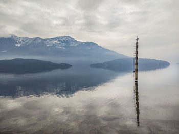 Mooring pole on lake como in a winter morning