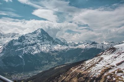 Scenic view of snowcapped mountains against cloudy sky