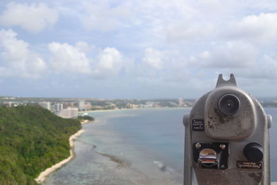 Coin-operated binoculars against cloudy sky