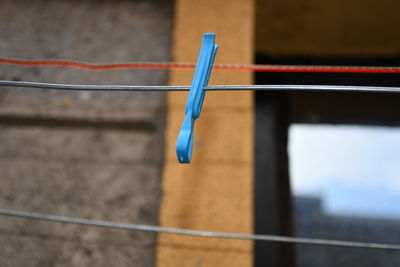 Close-up of clothespins hanging on fence