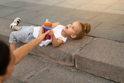 Woman giving bottle to daughter