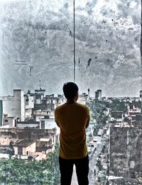 Rear view of woman standing in front of building