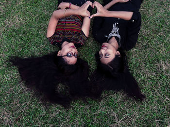 High angle view of friends lying on field